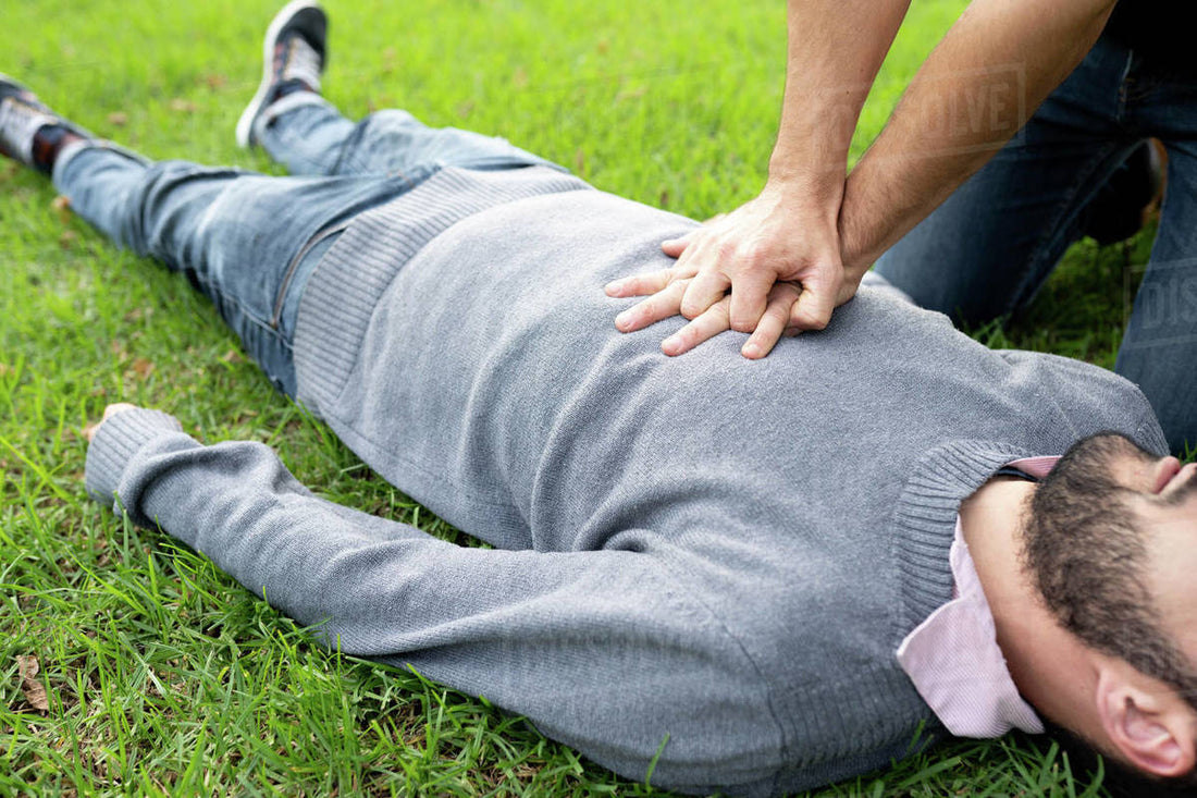 CPR being performed on a man on grass